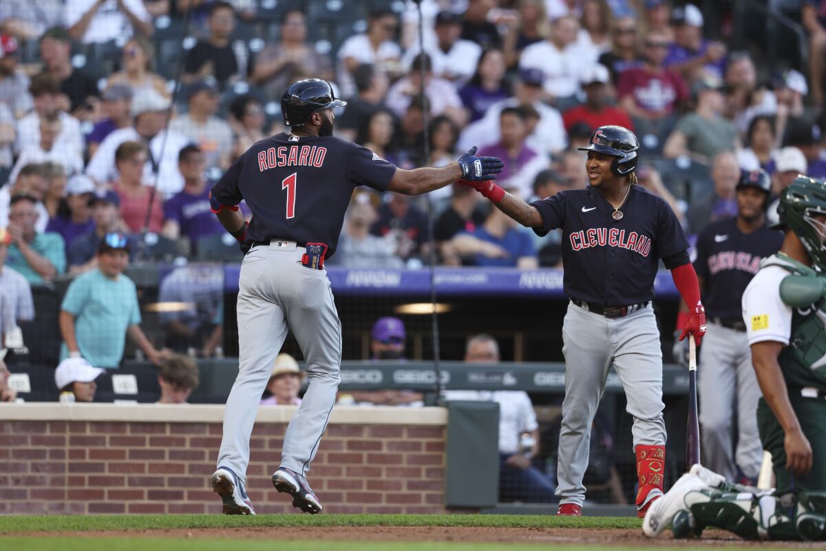 Cleveland Guardians' Amed Rosario, left, celebrates with Jose Ramirez after hitting a home run against the Colorado Rockies during the third inning of a baseball game Wednesday, June 15, 2022, in Denver. (AP Photo/Gabriel Christus)