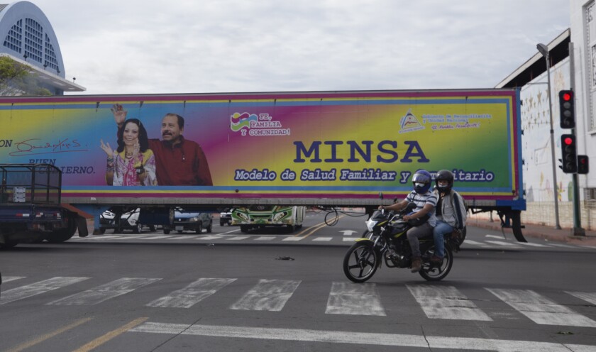 FILE - In this June 17, 2021 file photo, a billboard promoting President Daniel Ortega and his wife and Vice President Rosario Murillo covers a truck driving through Managua, Nicaragua. The U.S. State Department announced Monday, July 12, 2021 it is revoking the travel visas of 100 legislators, judges and prosecutors who aided the regime of President Daniel Ortega. (AP Photo/Miguel Andres, File)