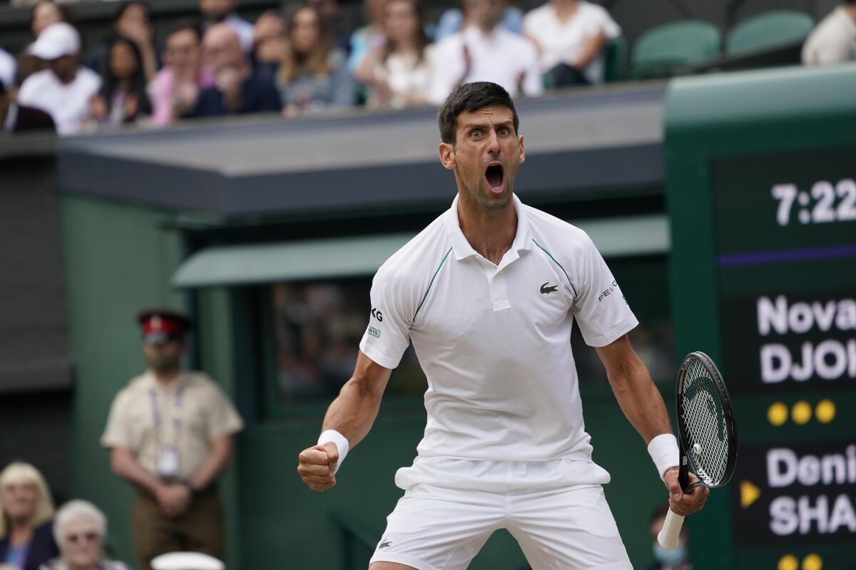 Serbia's Novak Djokovic celebrates after winning a point against Canada's Denis Shapovalov during the men's singles semifinals match on day eleven of the Wimbledon Tennis Championships in London, Friday, July 9, 2021. (AP Photo/Alberto Pezzali)