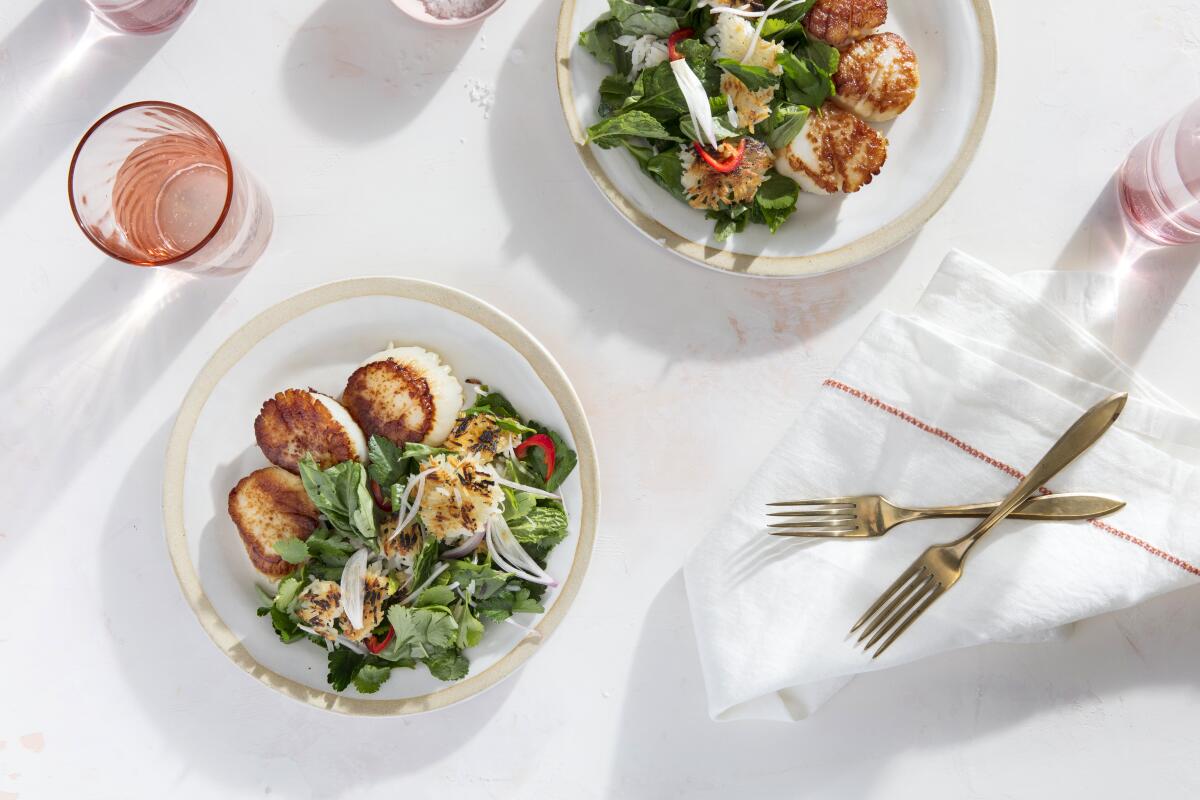 Super crispy rice chunks add crunch to a bright herb salad served with seared, plump scallops. Prop styling by Rebecca Buenik.