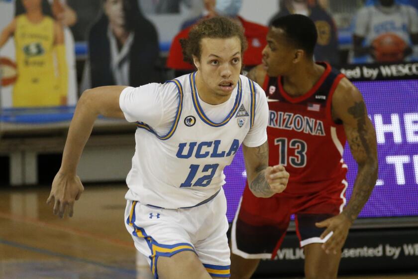 UCLA forward Mac Etienne (12) runs during an NCAA college basketball game between UCLA and Arizona.