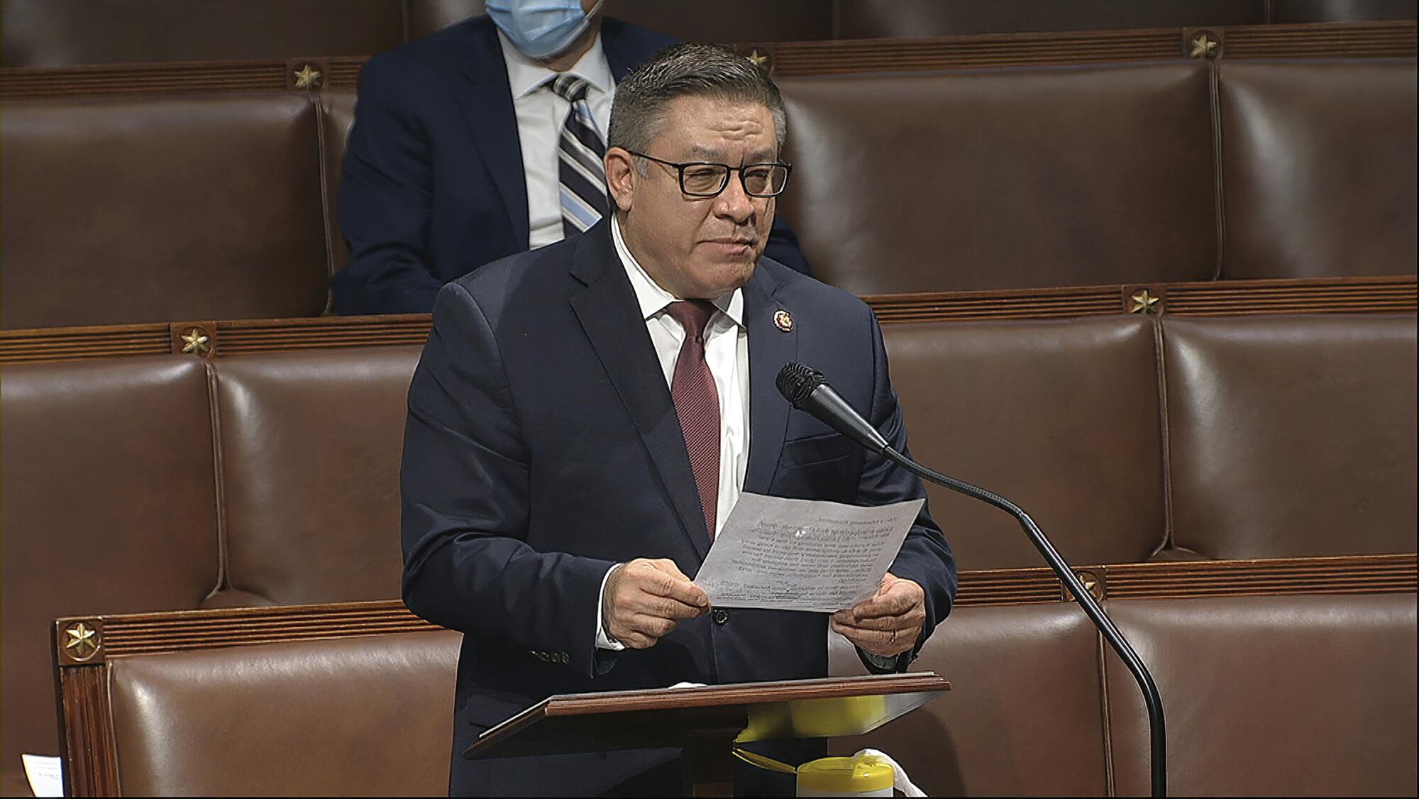   Um homem segurando um papel fala no plenário da Câmara dos Representantes, no Capitólio dos EUA, em Washington.