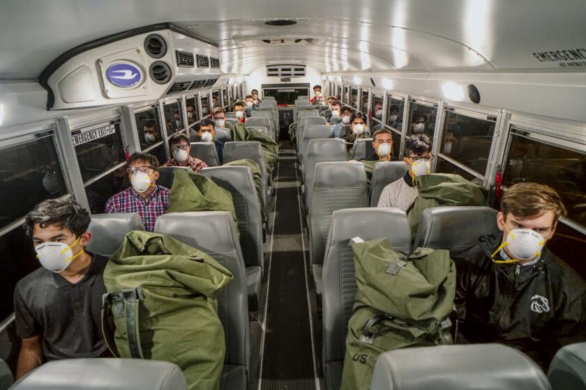 Marine recruits sit on a bus after receiving a health screening and getting their gear before heading to a hotel for quarantine at the Marine Corp Recruit Depot(MCRD) on Monday, April 13, 2020. New COVID-19 distancing practices have gone into effect for new recruits such as standing six feet apart, health screenings and a 14-day quarantine period before boot camp begins.