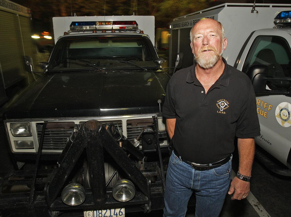 Jerry Hill stands in front of one of the Montrose Search and Rescue team patrol vehicles in La Crescenta on Tuesday, February 11, 2014. Hill recently retired after 34 years as a volunteer with the team.