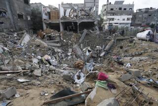 Palestinians look at the destruction after an Israeli strike at a residential building in Deir al Balah, Gaza Strip, Sunday, Jan. 14, 2024. (AP Photo/Adel Hana)