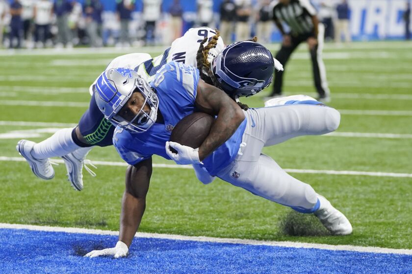 Detroit Lions running back Justin Jackson (42), defended by Seattle Seahawks safety Ryan Neal (26), catches a 2-yard pass for a touchdown during the second half of an NFL football game, Sunday, Oct. 2, 2022, in Detroit. (AP Photo/Paul Sancya)