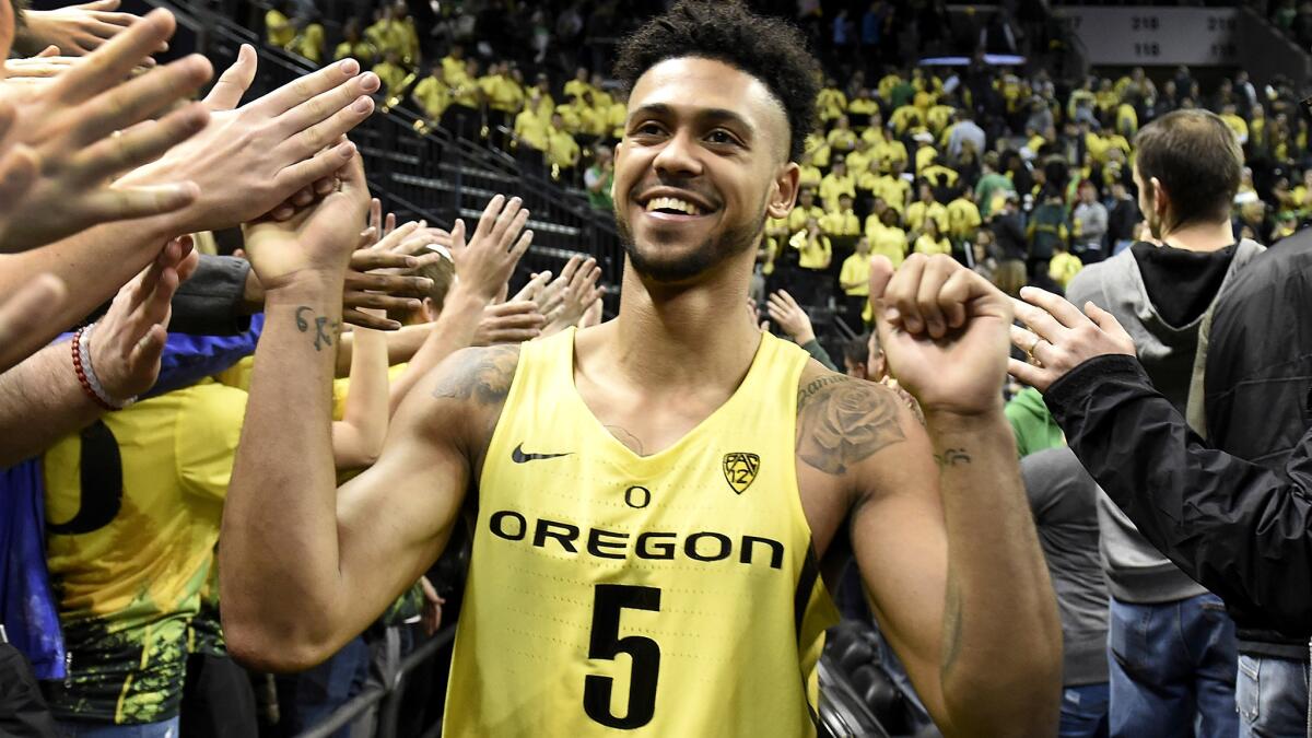 Oregon guard Tyler Dorsey (5) is congratulated by fans after the Ducks upset visiting Arizona on Saturday.