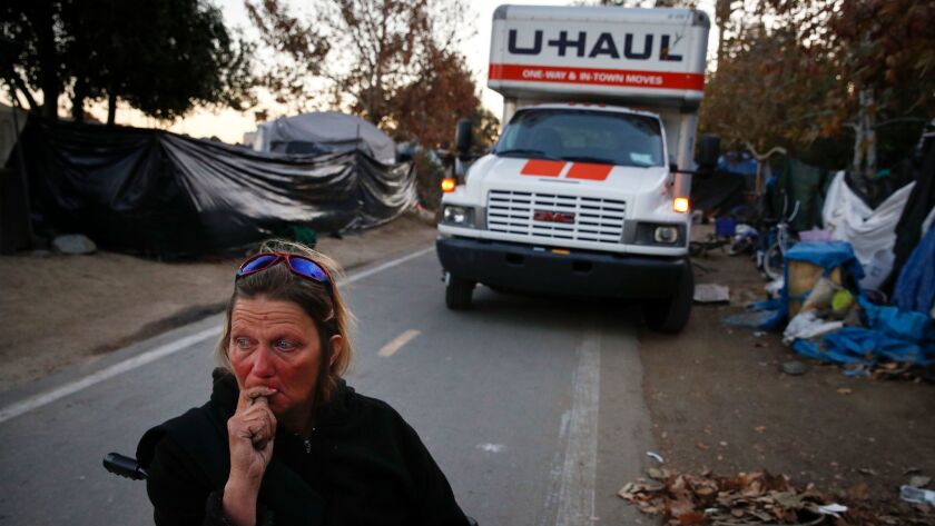 Denise Lindstrom, a 49-year-old homeless woman, sits in a wheelchair with tearful eyes in front of a moving truck in an homeless encampment on the Santa Ana River trail in Anaheim, Calif. on Jan. 22.