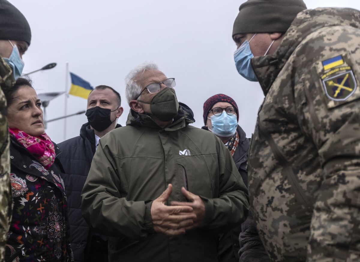 European Union foreign policy chief Josep Borrell chats with Ukrainian soldier during his visit to the Stanitsa Luganskaya border crossing between Ukraine and the territory controlled by pro-Russian militants in the Luhansk region, Ukraine, Wednesday, Jan. 5, 2022. (AP Photo/Andriy Dubchak)