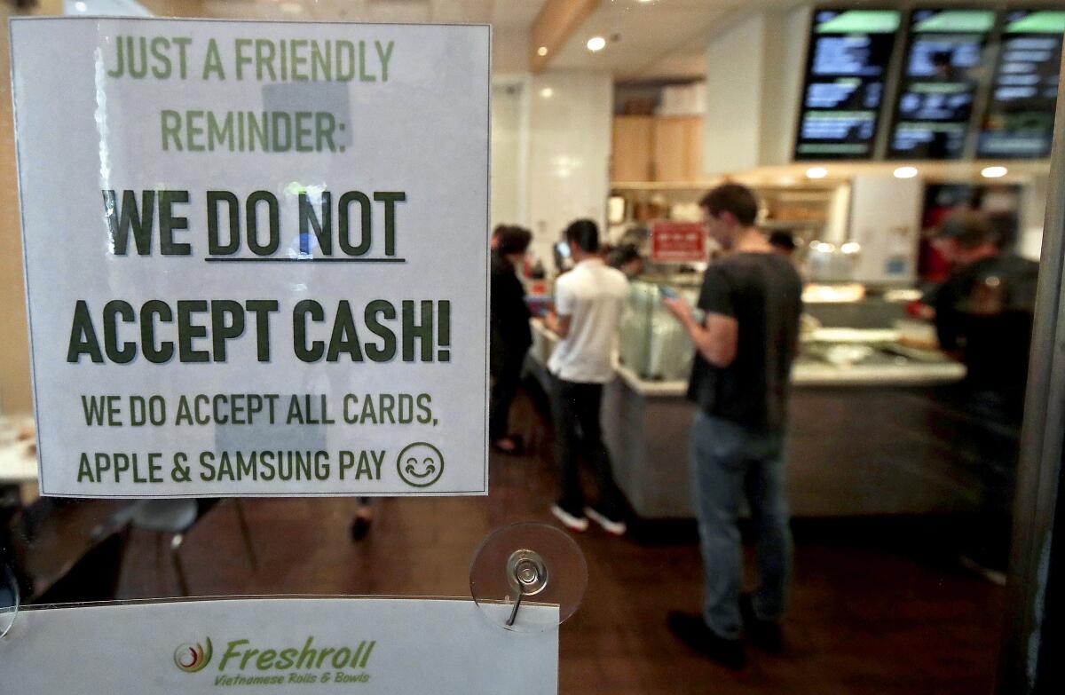 A sign posted on a door alerts customers at a store in San Francisco that cash is not accepted in 2019.