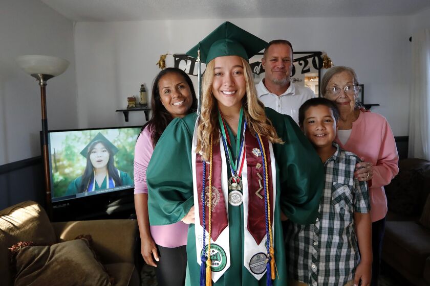 Honor student Jordan Galante, center, stands with family, mom Erika, dad Philip, brother Zion, and grandma June, from left, prior to watching Costa Mesa High Class of 2020 graduation ceremony via TV broadcast with her family at her home.