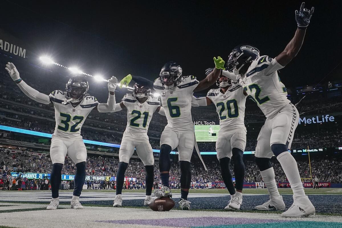 Seattle Seahawks players celebrate at the end zone.
