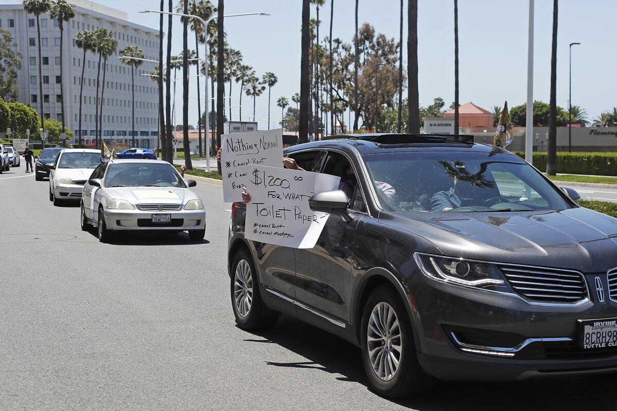 The Alliance of Californians for Community Empowerment members participate in a car rally as they drive by the Irvine Co. offices in Newport Beach in protest on Friday as part of a #MakeThemPay day of action organized by activists involved in the #CancelRent movement.