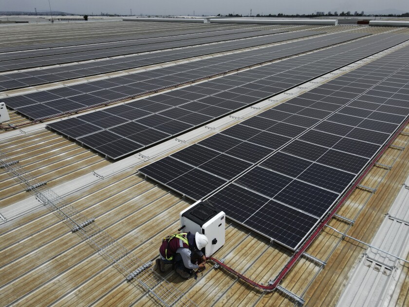 A worker works among the Solar Panels installed by Pireos Power on the roof of a warehouse
