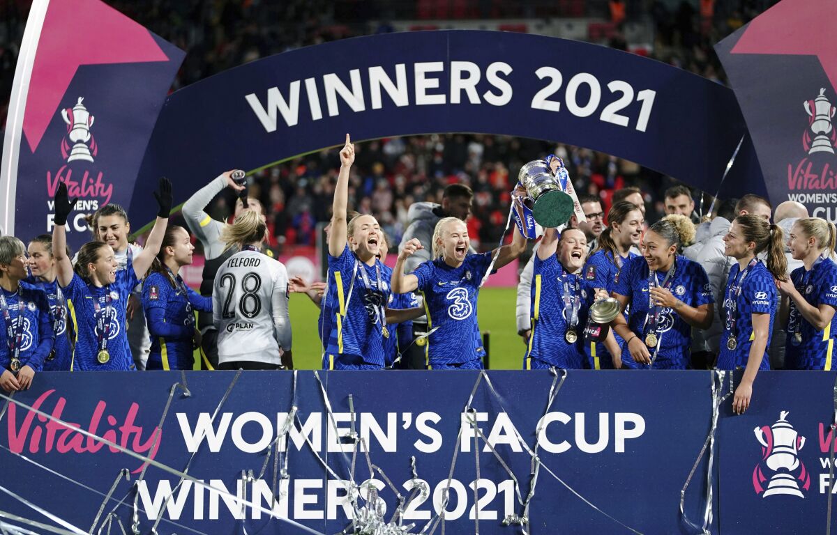 Chelsea's Magdalena Eriksson, centre left, Pernille Harder, centre, and Erin Cuthbert, centre right, celebrate with the trophy after the women's FA Cup soccer final match between Arsenal and Chelsea, at Wembley Stadium, in London, Sunday, Dec. 5, 2021. (Zac Goodwin/PA via AP)