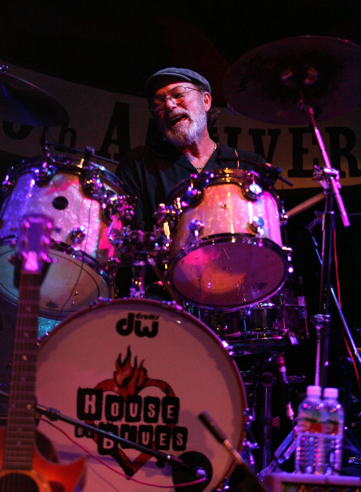 A bearded man plays the drums