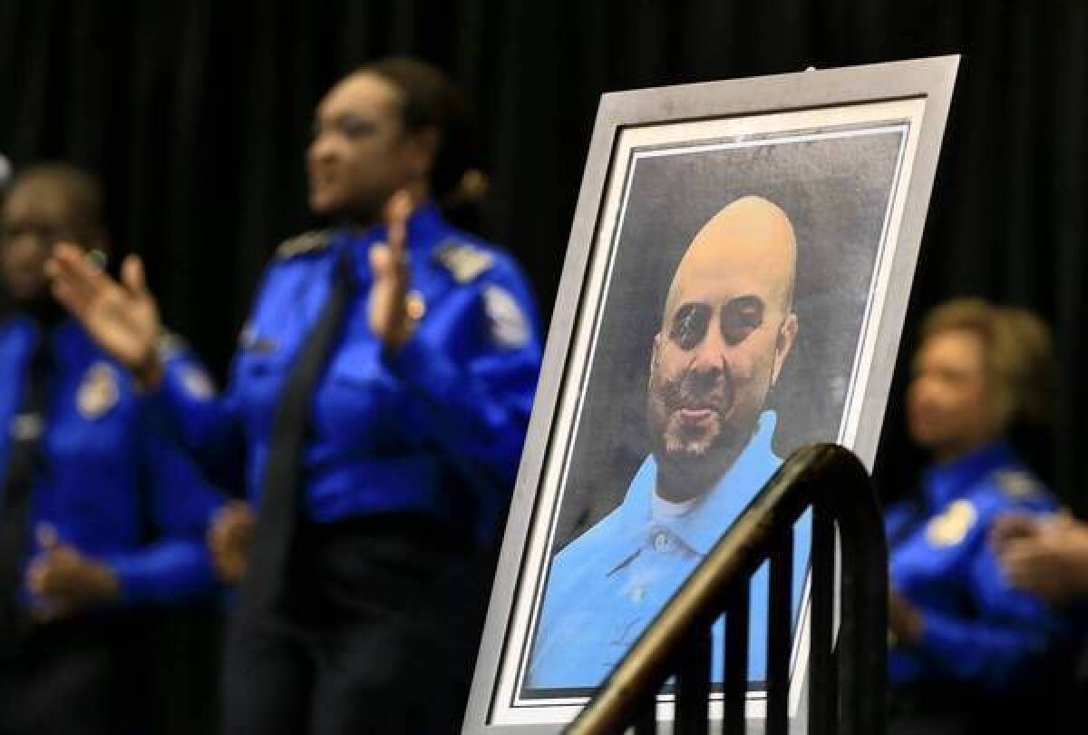 The TSA Chorus sings in tribute to slain Transportation Security Administration officer Gerardo Hernandez, whose photo is set up on stage during a public memorial at the Los Angeles Memorial Sports Arena earlier this month.