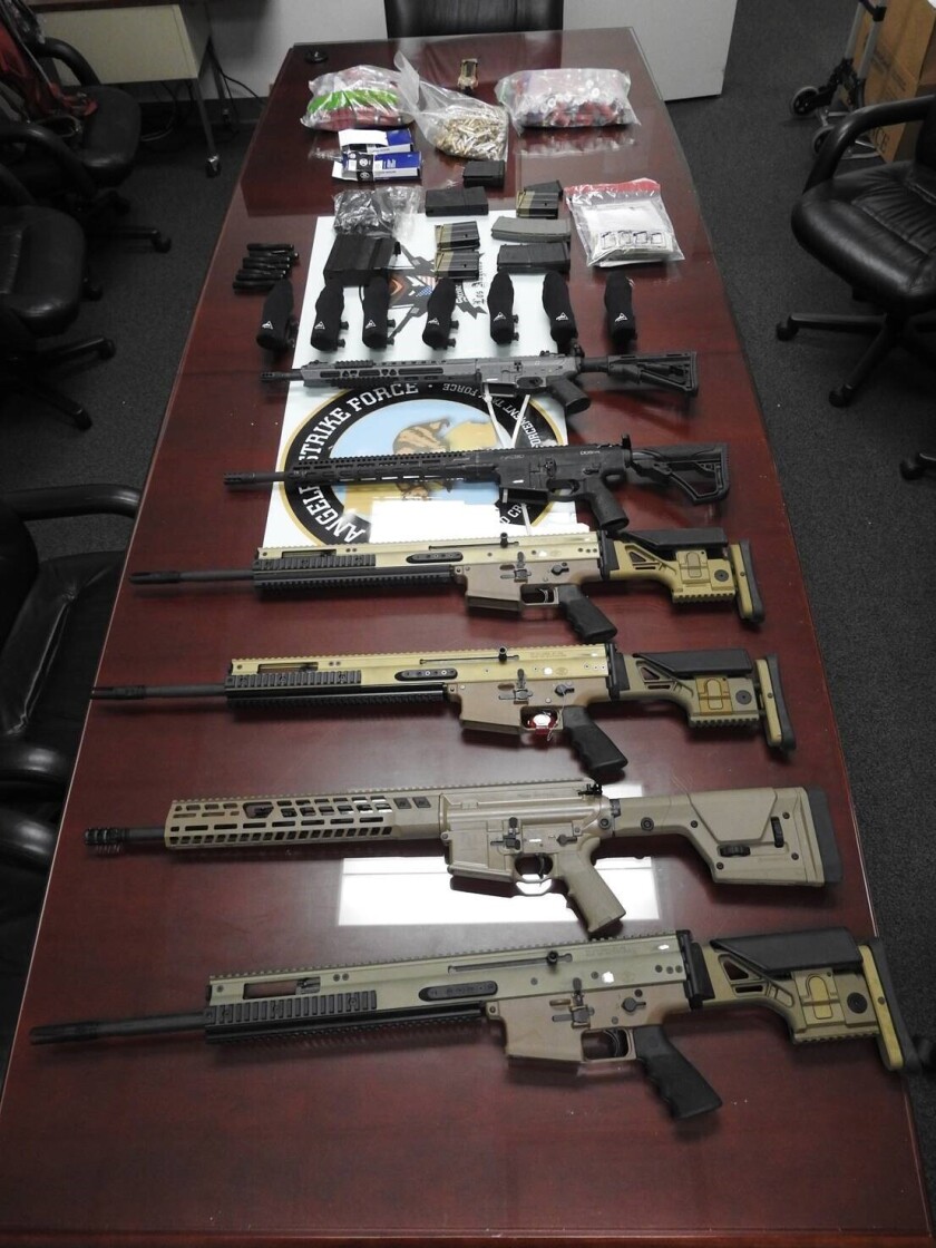 This undated photo provided by the United States Department of Justice shows high-powered firearms and ammo. Six men have been charged with plotting to smuggle assault weapons and hundreds of thousands of rounds of ammunition, including .50-caliber armor piercing bullets, to one of Mexico's most violent drug cartels, authorities announced Monday, Jan. 24, 2022. (USDOJ via AP)