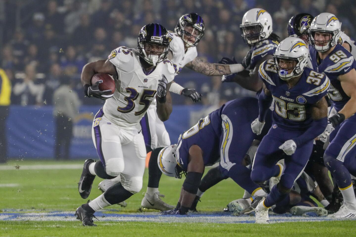 Ravens running back Gus Edwards sprints past Chargers defenders for a 43-yard run on the first play from scrimmage at StubHub Center.