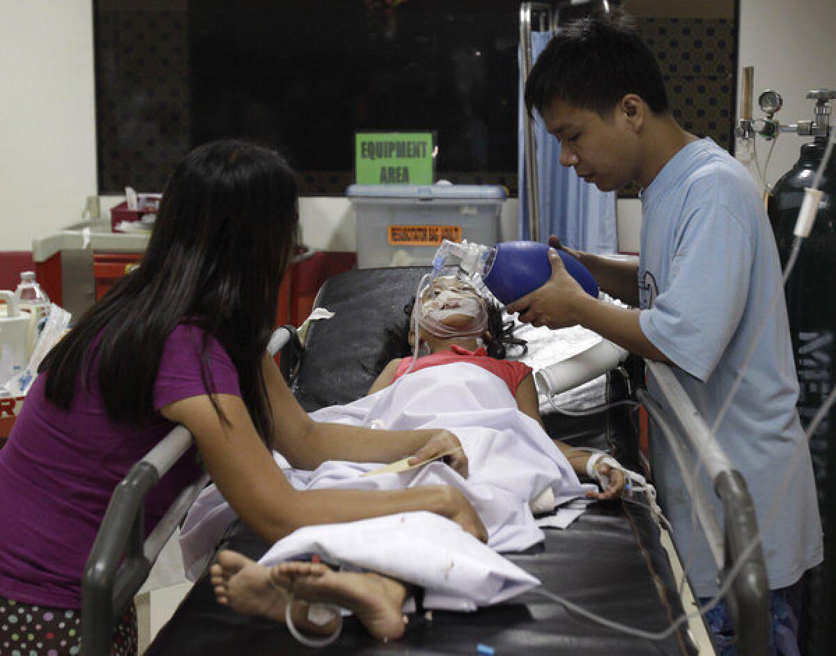 Seven-year-old Stephanie Nicole Ella lies in a bed Tuesday as her parents aid in giving her life support while being treated at the East Avenue Medical Center in suburban Quezon city, north of Manila.