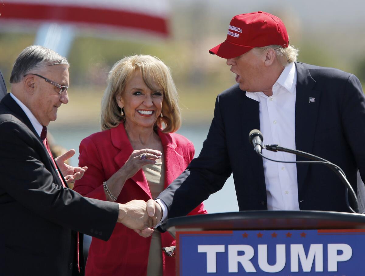 Maricopa County Sheriff Joe Arpaio, left, and former Arizona Gov. Jan Brewer greet Republican presidential candidate Donald Trump at a rally in Fountain Hills, Ariz., on March 19, 2016.