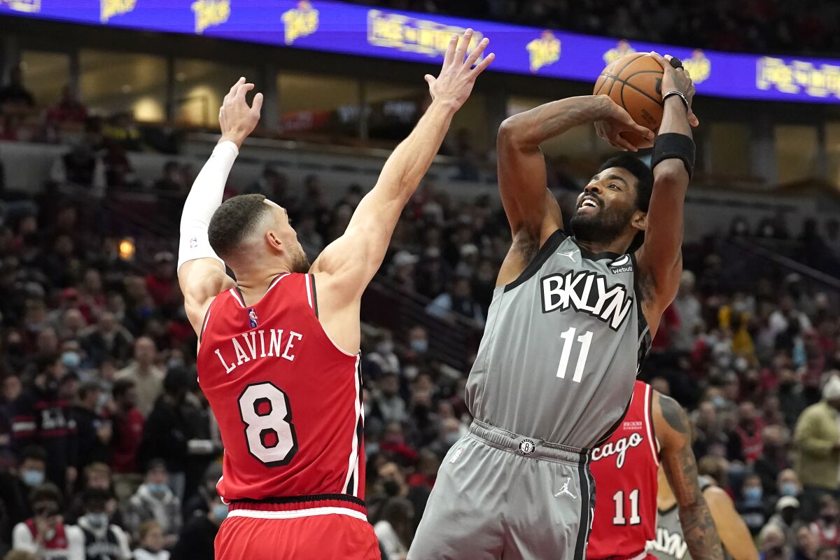 Brooklyn Nets' Kyrie Irving (11) shoots over Chicago Bulls' Zach LaVine during the first half of an NBA basketball game Wednesday, Jan. 12, 2022, in Chicago. (AP Photo/Charles Rex Arbogast)