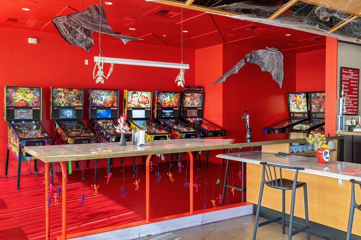 A row of vintage pinball machines off the dining room at Poltergeist in Button Mash in October 2023.