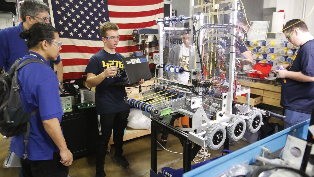 Avery Levin from Marina High School in Huntington Beach makes final adjustments on his team's robot during the FIRST Robotics Competition on Friday at the OC Fair & Event Center in Costa Mesa.