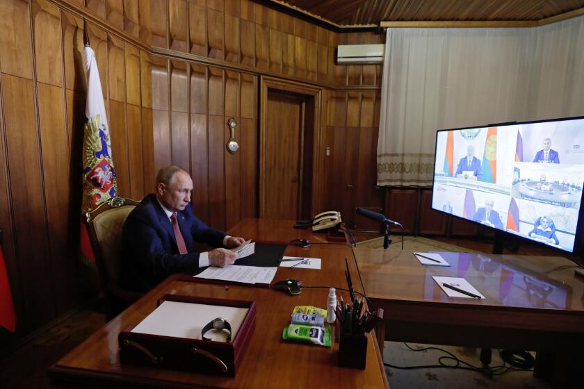 Russian President Vladimir Putin attends a meeting of the Supreme State Council of the Union State of Russia and Belarus via videoconference from Sevastopol, Crimea, Thursday, Nov. 4, 2021. Belarusian President Alexander Lukashenko in in the left corner of the computer's screen. (Mikhail Metzel, Sputnik, Kremlin Pool Photo via AP)