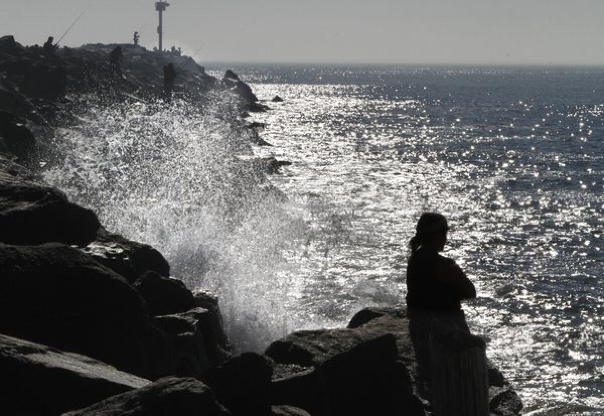 Waves crash against the West Jetty of Newport Bay. The National Weather Service warned that an ocean swell could produce deadly "sneaker" waves along the coastline, and advised people against fishing from rocks of jetties through at least Tuesday afternoon.