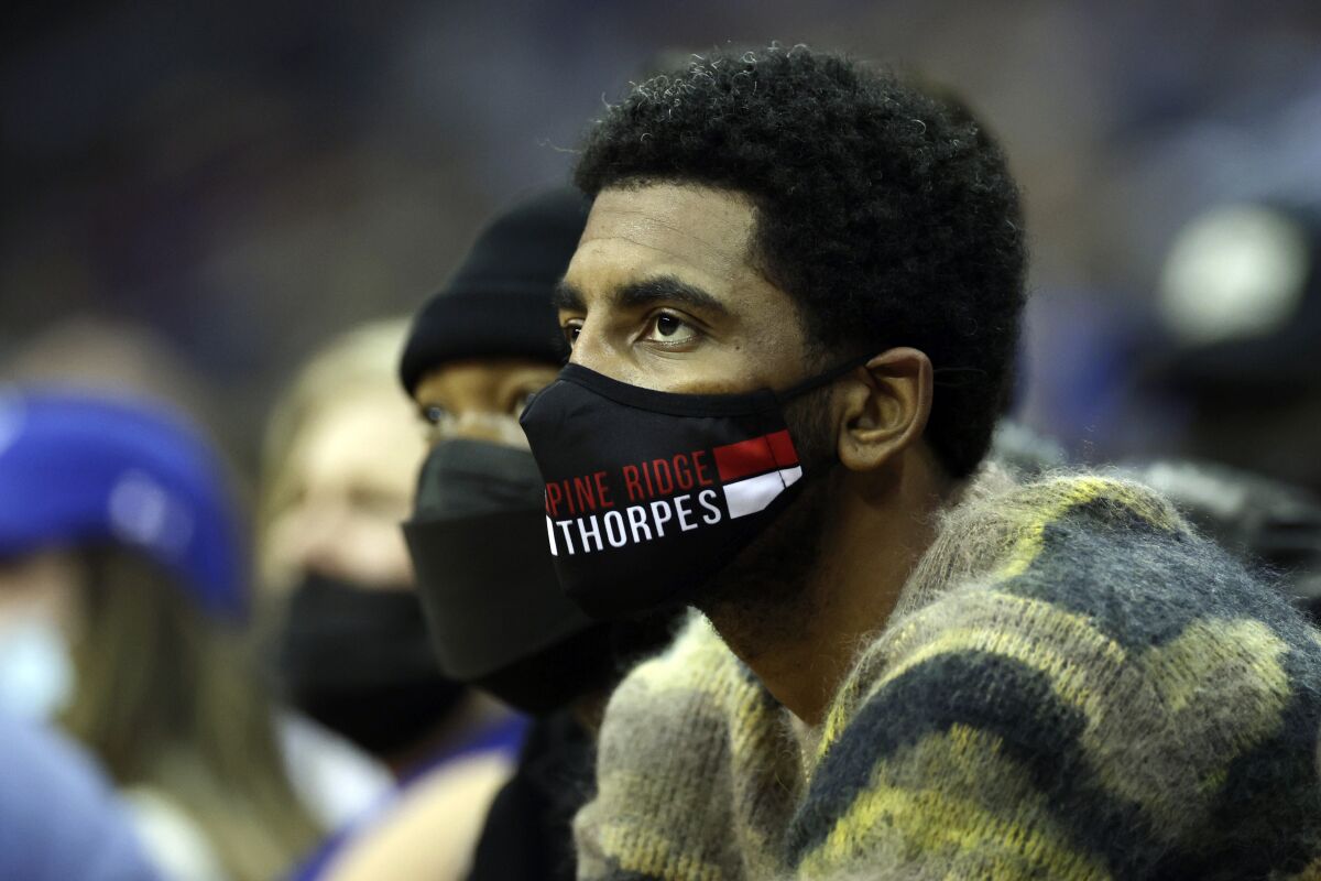 Brooklyn Nets' Kyrie Irving watches the first half of an NCAA college basketball game between Villanova and Seton Hall on Saturday, Jan. 1, 2022, in Newark, N.J. (AP Photo/Adam Hunger)