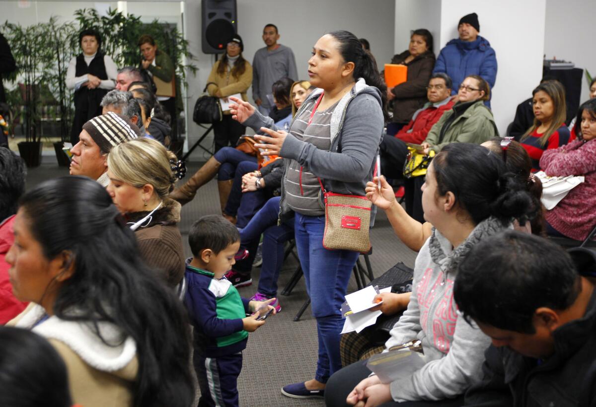 Rosa Robles asks about eligibility to stay in the U.S. as her son Alan Gomez, 3, stands near her at a workshop on applying for deferment from deportation in McAllen, Texas.