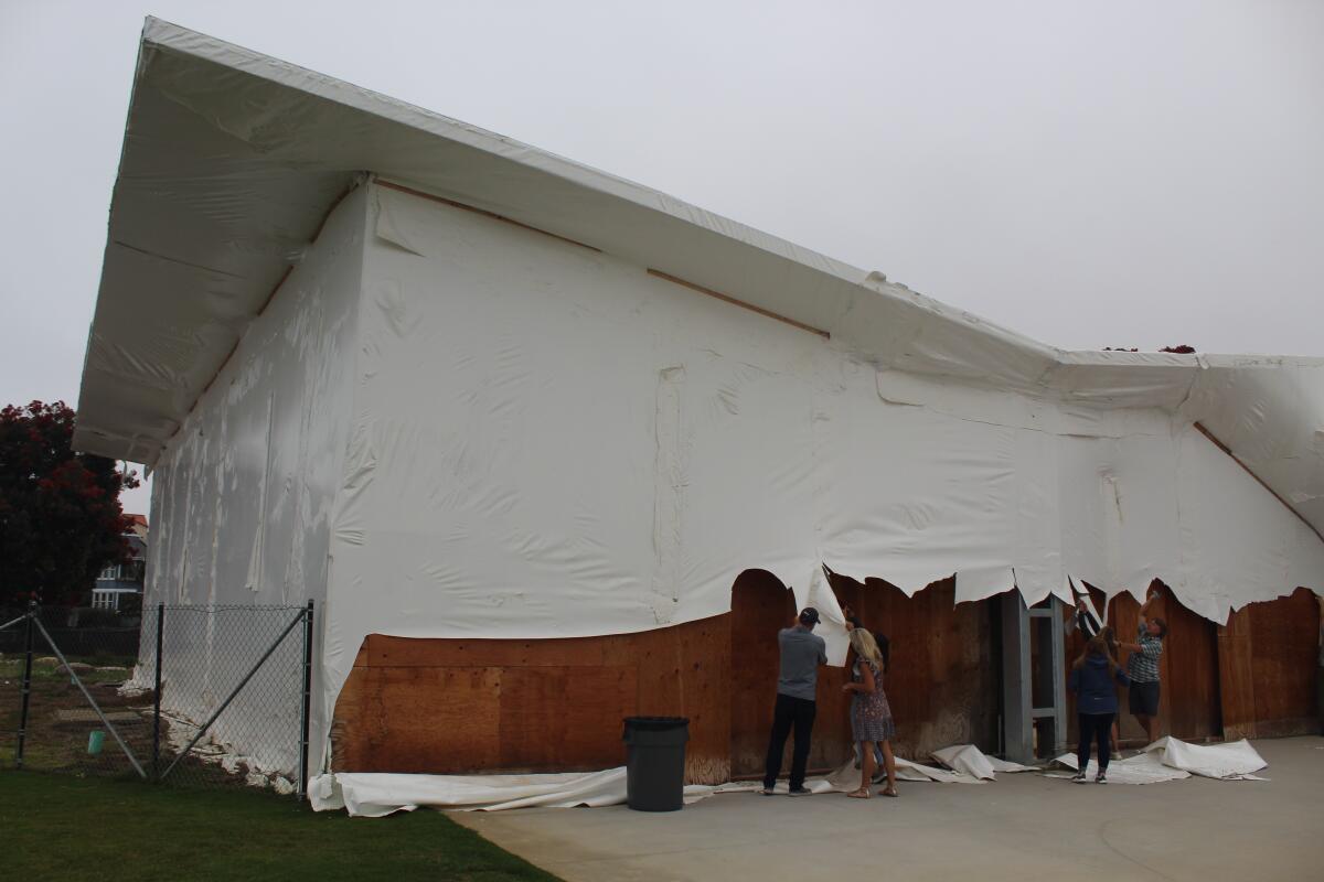 Cardiff School District staff cut off the plastic wrapping on the Cardiff School multipurpose building.