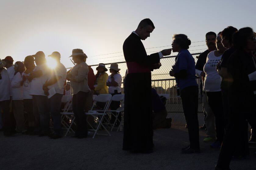 FILE - Migrants watching Pope Francis' Mass in Juarez, Mexico, from a levee along the banks of the Rio Grande in El Paso, Texas, take part in Communion, Wednesday, Feb. 17, 2016. According to a poll from The Associated Press-NORC Center for Public Affairs Research conducted in mid-May 2022, only 31% of lay Catholics agree that politicians supporting abortion rights should be denied Communion, while 66% say they be allowed access to the sacrament. (AP Photo/Eric Gay, File)