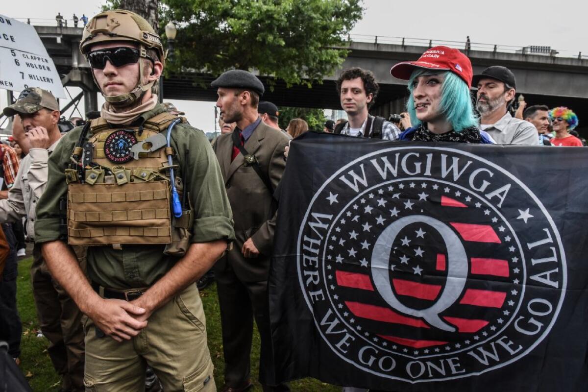 A person holds a banner referring to the Qanon conspiracy theory during a alt-right rally on August 17, 2019 in Portland, Oregon. Epoch Times has come to be known for spreading such conspiracy theories.