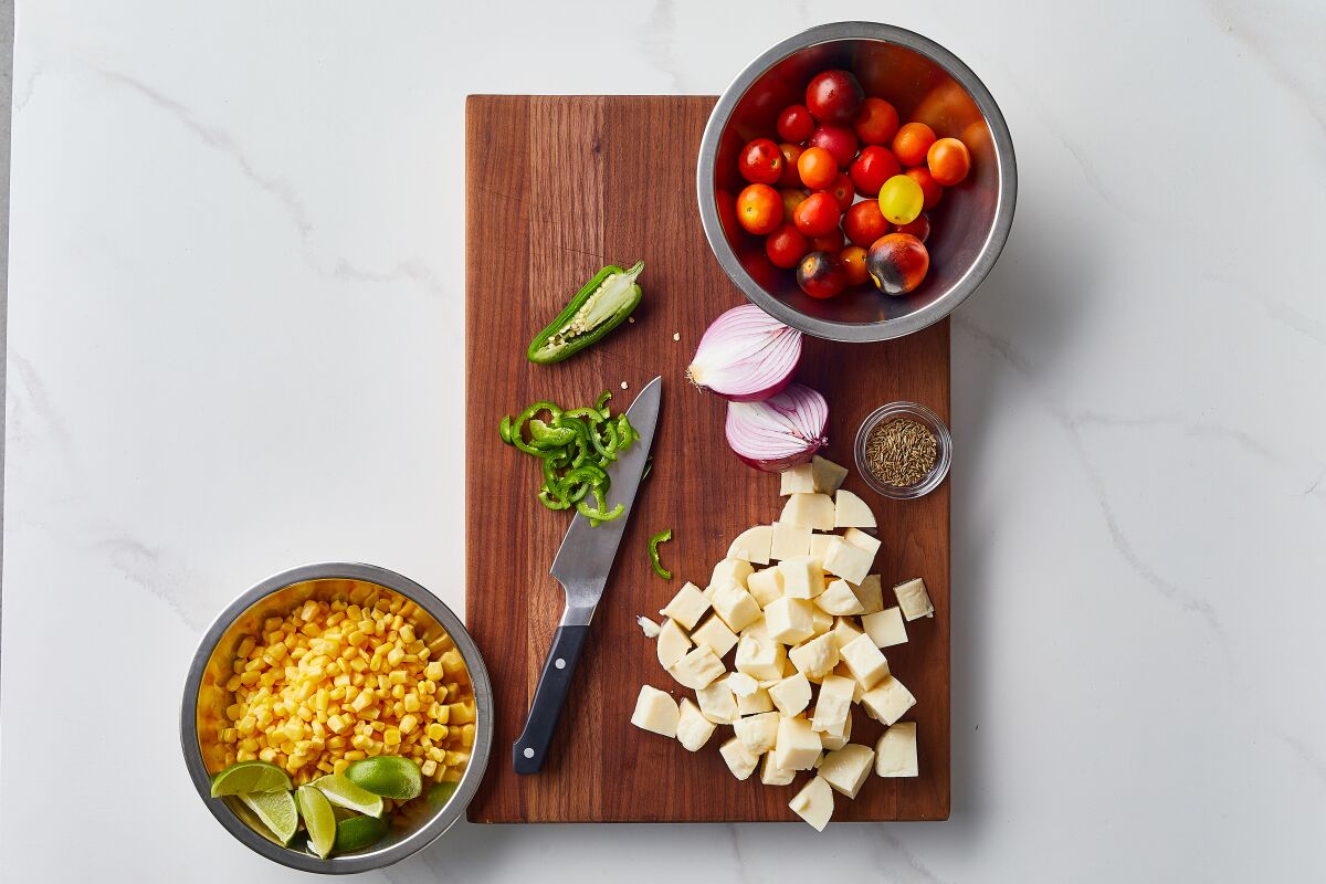 Ingredients to make halloumi with corn, cherry tomatoes and basil, raw red onion and jalapeno.