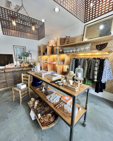 A shop with clothes and sandals and home decor.
