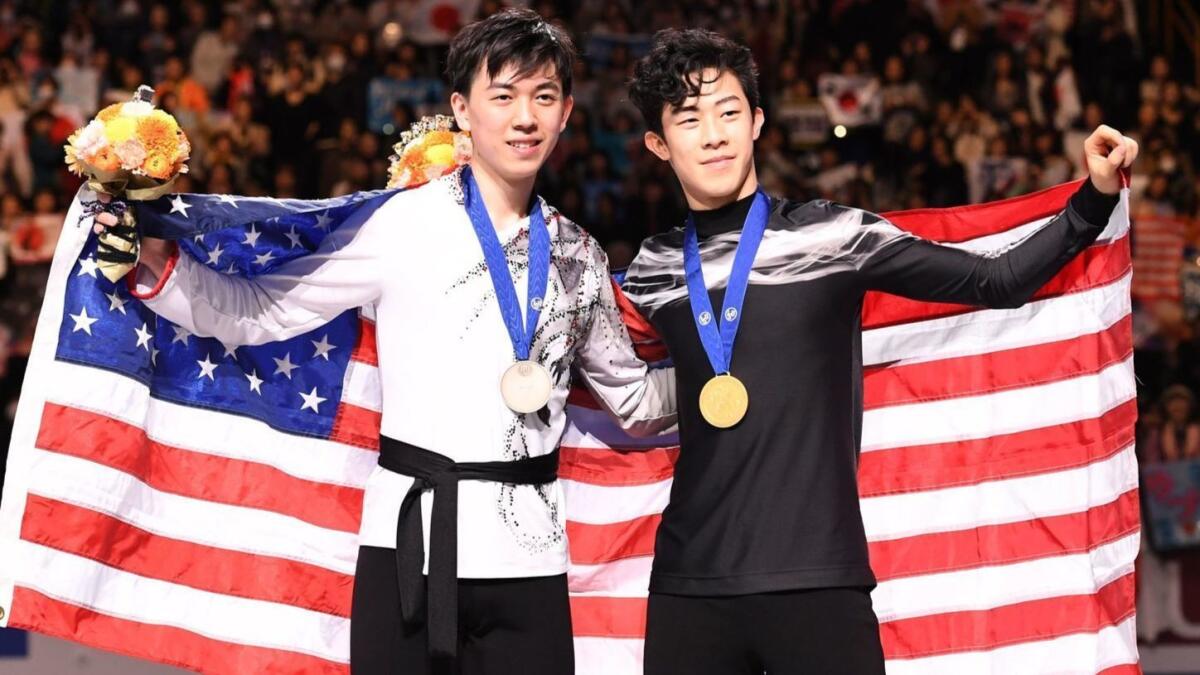 Gold medalist Nathan Chen, right, and bronze medalist Vincent Zhou pose for a photo after the figure skating world championships on Saturday.
