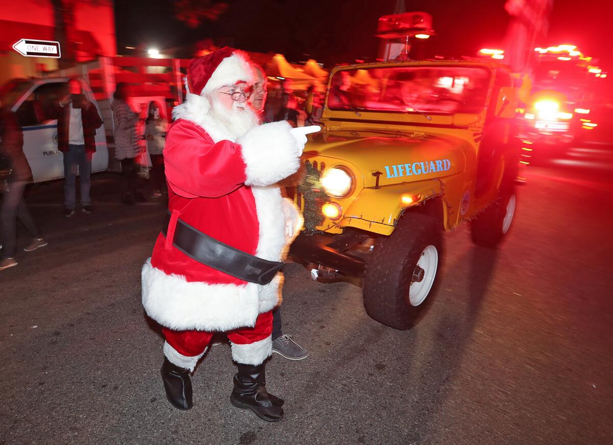 Santa Claus waves to families as he arrives via lifeguard Jeep to the Peppertree Lot stage during Hospitality Night.