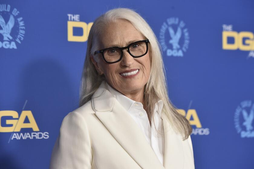 Jane Campion posing in glasses and a white suit