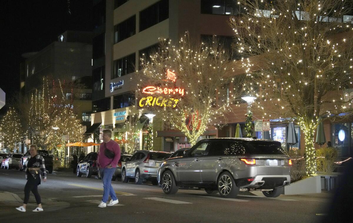 Dos personas cruzan una avenida en el distrito comercial Cherry Creek North