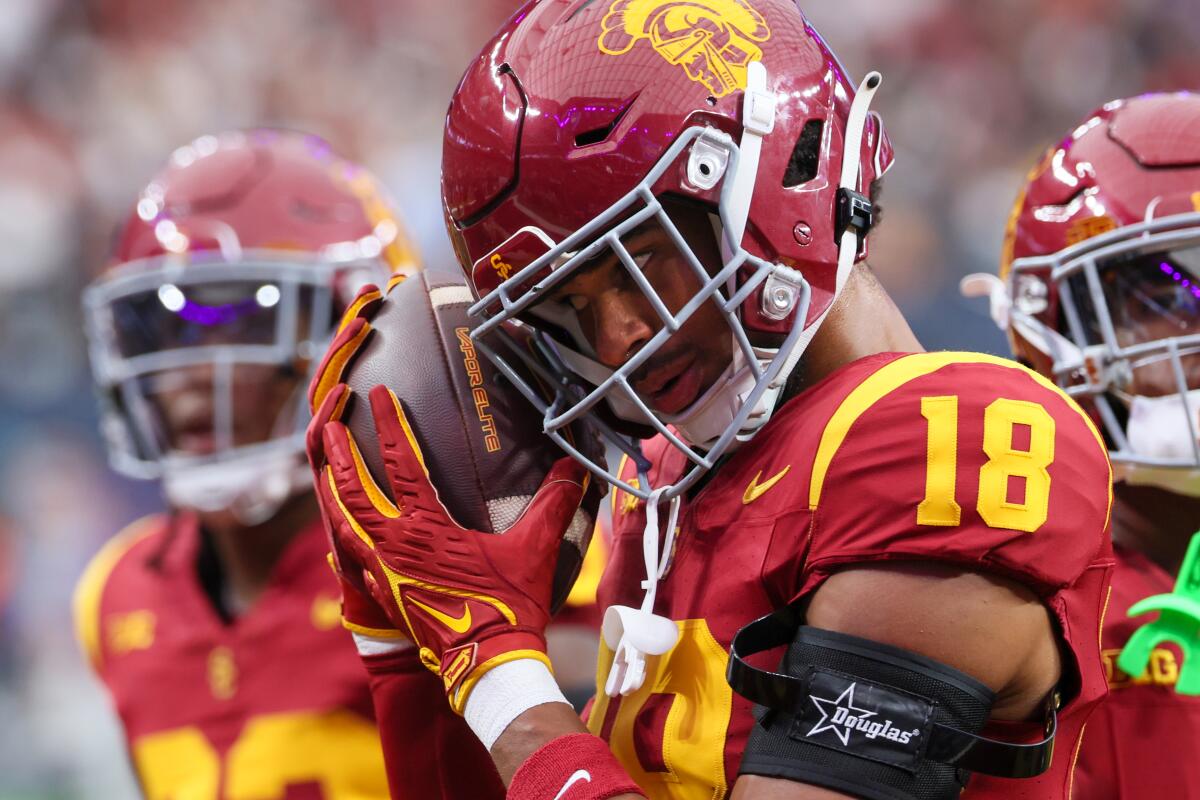 USC linebacker Eric Gentry playfully cuddles a football during pregame warmups.