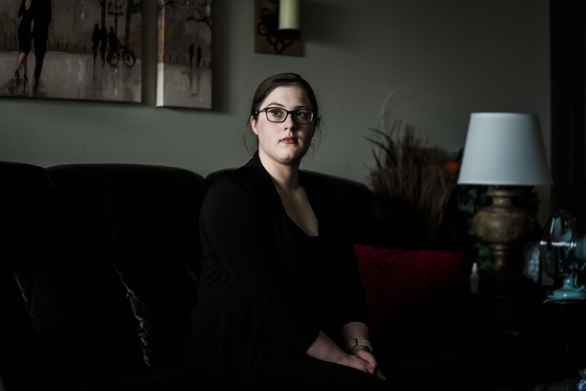 Sarah Blahovec sits on her couch at home.