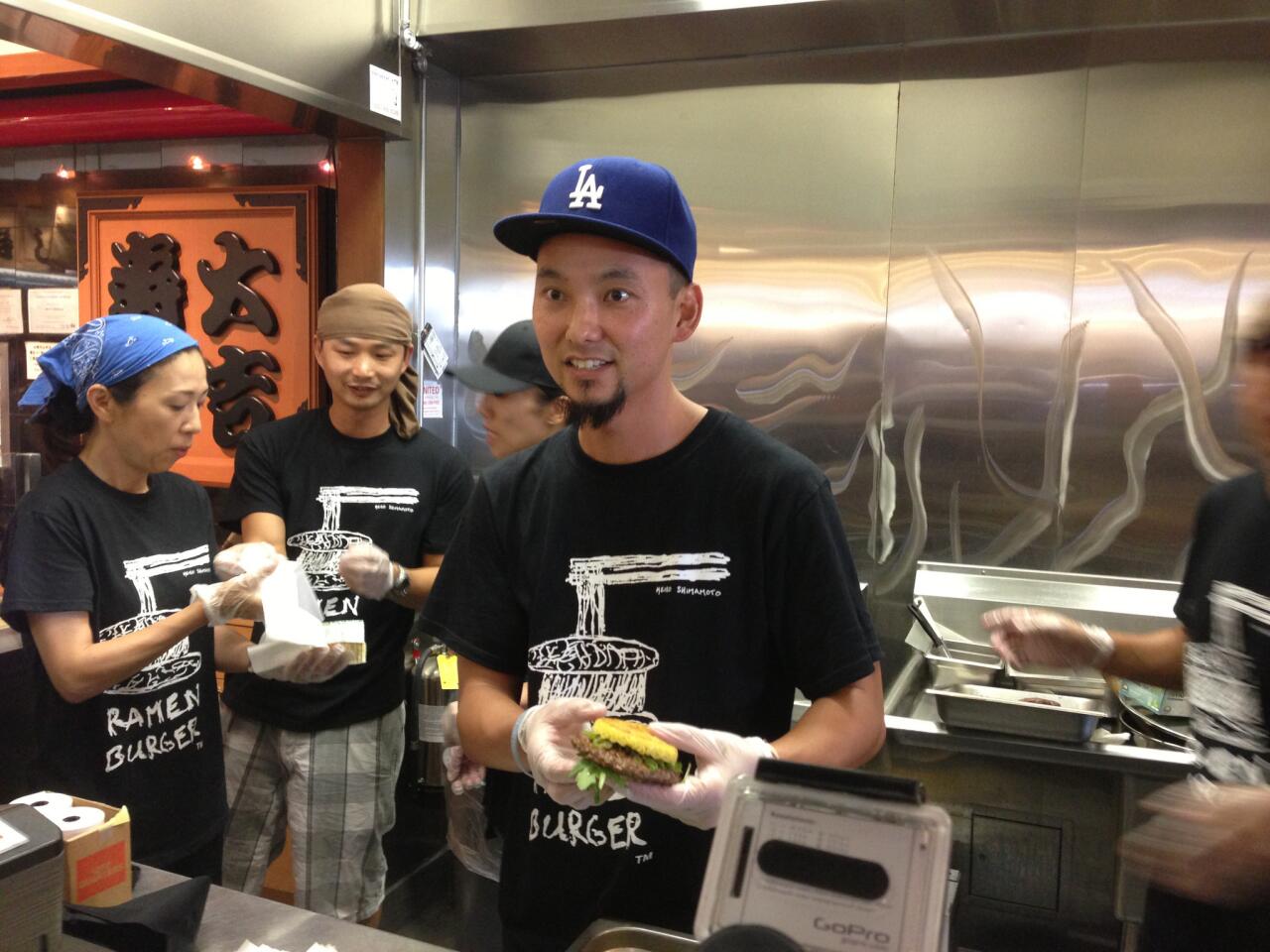 Keizo Shimamoto holds one of the Ramen Burgers.