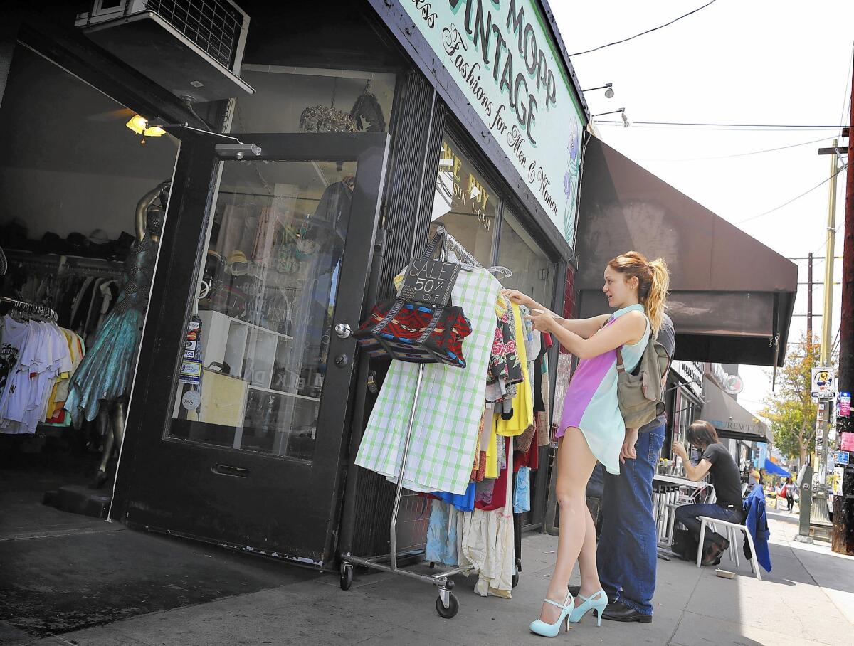 A customer checks out clothes on a rack outside Ragg Mopp Vintage in Silver Lake.
