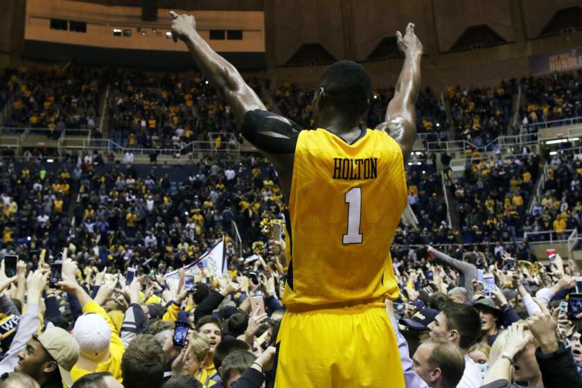 West Virginia forward Jonathan Holton celebrates after his team defeated Kansas, 74-63, during a game on Jan. 12.