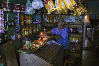 A man lights a candle in his shop during a blackout in Caracas, Venezuela, Friday, Aug. 30, 2024. (AP Photo/Ariana Cubillos)