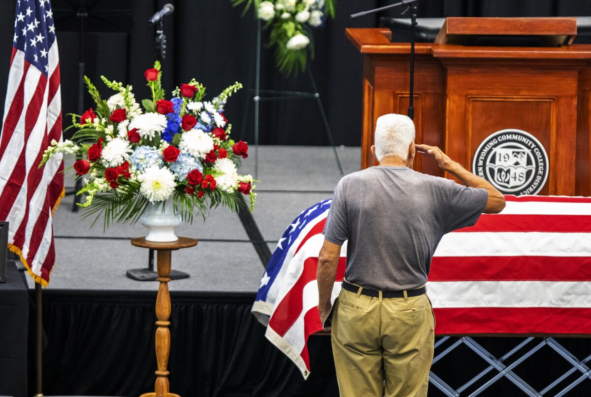 The casket of Sen. Mike Enzi is saluted by a man during the visitation portion of Enzi's funeral service at the Pronghorn Center in Gillette, Wyo. on Friday, Aug. 6, 2021. The former U.S. Senator was remembered Friday as an honorable statesman and family man who was focused on leadership, tradition and faith. (Mike Moore/Gillette News Record via AP)