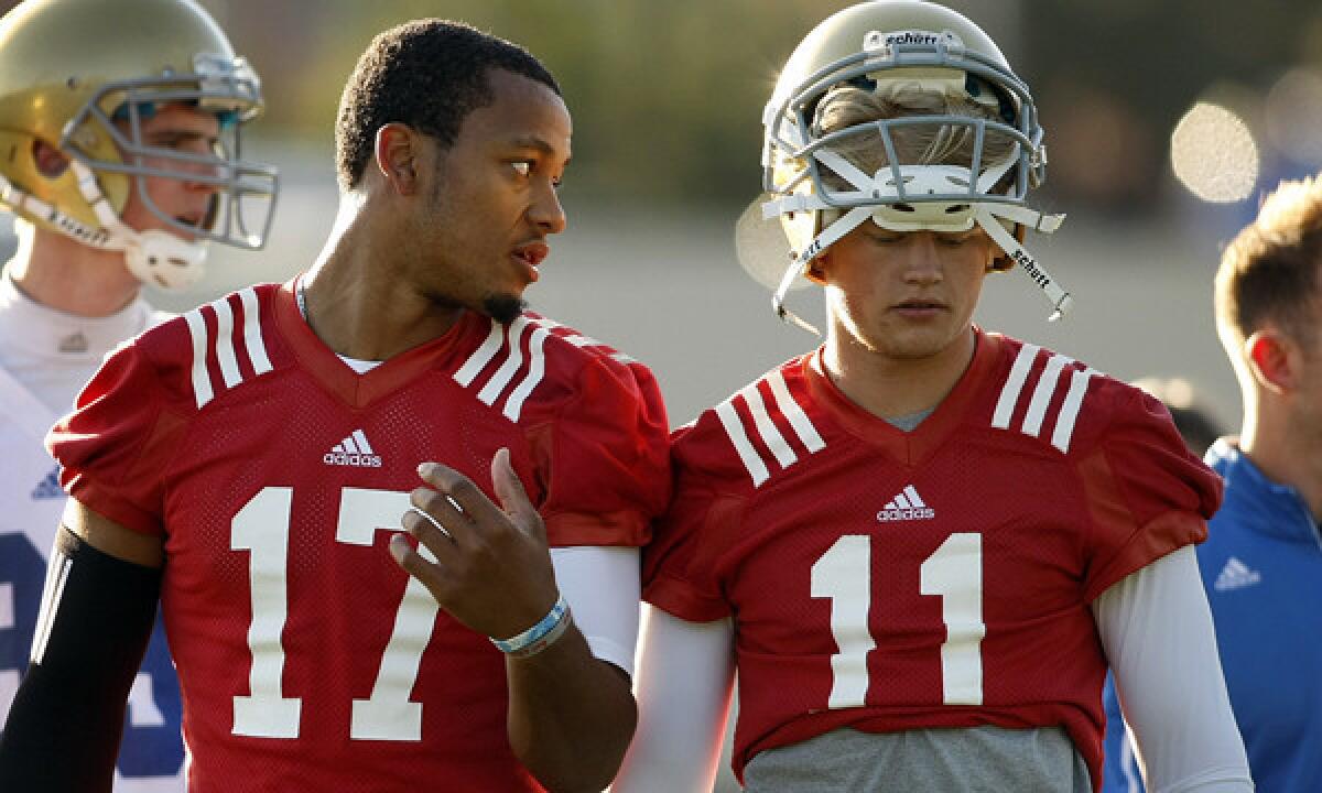 UCLA quarterback Brett Hundley, left, speaks with quarterback Jerry Neuheisel during a spring practice session on April 1. Nueheisel is competing with Asiantii Woulard for the Bruins' backup quarterback role.