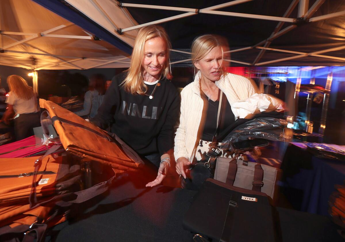 Jessica Glowaki and Michelle Gillespie, from left, shop Nalu clothing and accessories during Monday night's pop-up event.